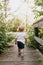Cute Little Blond Boy Kid Walking on Tiny Wooden Bridge Outside at the Park while Exploring on an Adventure in New York Summer