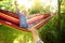 Cute little blond caucasian boy relaxing and having fun with multicolored hammock in backyard or outdoor playground. Child jumping