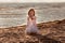 Cute little blond girl playing with falling sand at the beach