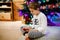 Cute little blond kid boy using smartphone on Christmas with decorated tree on background. Happy healthy hild having fun