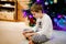 Cute little blond kid boy using smartphone on Christmas with decorated tree on background. Happy healthy hild having fun