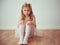 Cute little blonde girl sitting in ballet tutu