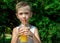 Cute little boy with blonde hair drinking orange lemonade outdoor