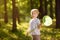 Cute little boy catches butterflies with scoop-net on sunny meadow.Study of nature. Young naturalist