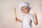 A cute little boy in a chef`s costume cooks food with emotions