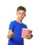 Cute little boy with cup of popcorn switching channels on white background