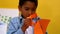 Cute little boy cutting paper shapes in classroom