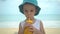 Cute little boy drinking fresh tropical mango smoothie shake in beach. Summertime concept.