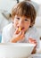 Cute little boy eating chips lying on the floor