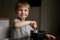 Cute little boy eating oatmeals for beakfast dreamily looking at the window. image with selective focus