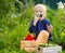 Cute little boy enjoy organic harvest in domestic garden. Child having fun. Cucumber smile