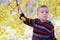 Cute little boy enjoying autumnal nature. Portrait of boy in Autumn Woods.