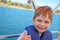 Cute little boy enjoying ride on a small boat.