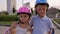 Cute little boy and girl in helmets hugging in the Park and eating ice cream.