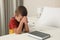 Cute little boy with hands clasped together saying bedtime prayer over Bible at home. Space for text