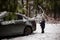 Cute little boy helping to brush snow from a car on winter snowy day