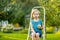 Cute little boy helping to harvest apples in apple tree orchard in summer day. Child picking fruits in a garden. Fresh healthy