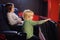 Cute little boy with his mother watching cartoon movie in the cinema