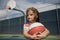 Cute little boy holding a basket ball trying make a score.