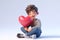 a cute little boy hugging a big red heart, ai generated