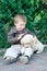 Cute little boy kneeling with his puppy labrador smiling at camera