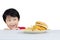 Cute little boy peeping tasty hamburger