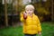 Cute little boy picking mushroom in autumn day