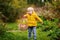 Cute little boy picking mushroom in basket