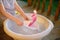 Cute little boy playing with homemade ship in basin of water on the porch of house. Kids play