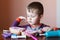 Cute little boy playing with many-colored plasticine. Boy playing with toys Dental Tools. Facial expression. Positive, negative