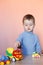 A cute little boy playing with model car collection. Toy mess in child room.