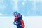 Cute little boy playing outside and throwing snowballs in winter