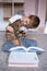 Cute little boy reading a book with a cat. Home schooling. Distance learning. Holidays. Quarantine during the