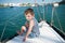 Cute little boy in shorts and a striped t-shirt sits on Board the yacht in sea port