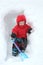 Cute little boy with shovel digs a snow cave in a large snowdrift. Winter fun concept