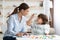 Cute little boy showing and pronouncing sound O with his teacher, exercising together at classroom, free space