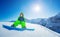 Cute little boy sit on snowboard over mountain top