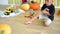 Cute little boy in skeleton costume playing with pumpkin at home