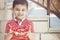 Cute little boy smiling and holding a bowl of freshly picked cherry berries. Copy space. Childhood and summertime concept