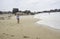 Cute little boy standing in the sand of a beautiful beach in Brittany,  imitating taking a picture of the sea