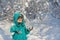 Cute little boy stands under falling snow