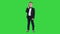 Cute little boy talking on his smartphone and standing in a dark suit on a Green Screen, Chroma Key.