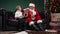 Cute little boy tells Santa Claus about his dreams and receives cherished gift. Grandson and grandfather in a red suit