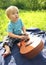 Cute little boy with ukulele Hawaiian guitar outdoor. Baby exploring musical instrument