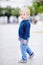 Cute little boy walking on cloudy autumn or spring day