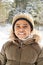 Cute little boy in warm jacket and knitted beanie hat enjoying stroll in park