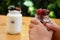 Cute little boys hold in their hand a jar of yogurt or pudding with their strawberries and cherries, in nature, on a