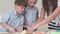 Cute little boys rolling dough for the cookies together with mom