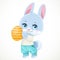 Cute little bunny holds orange Easter painted egg in paws