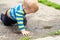 Cute little caucasian blond toddler boy having fun lying in a puddle after rain outdoors. Curious child discovering